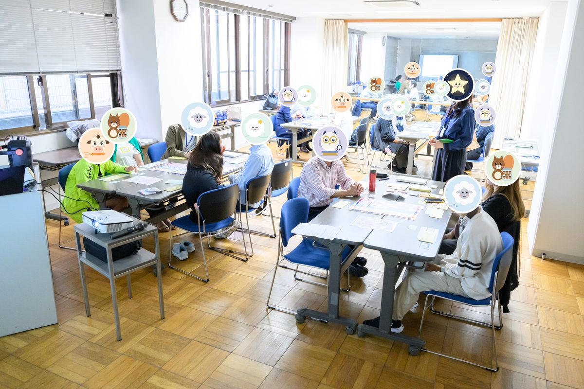 会場全体のようす。いくつものテーブルで、参加者がゲームをしている（顔はキャラクターで隠しています）