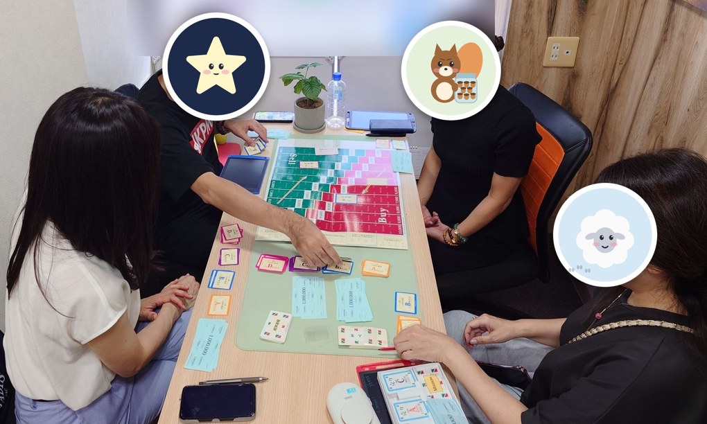 テーブルを囲んで、ボードゲームの盤とカードで遊ぶ参加者のようす（顔はキャラクターで隠しています）